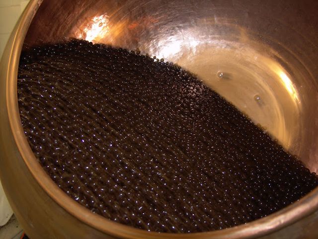 Chocolate-coated pieces inside a copper confectionery pan